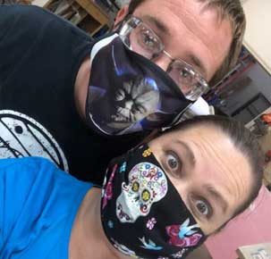 A man and woman wearing face masks posing for the camera.