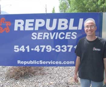 A man standing in front of a republic services sign.
