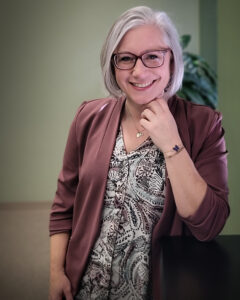 A woman with glasses and white hair posing for the camera. Human Resources Manager of Southern Oregon Aspire