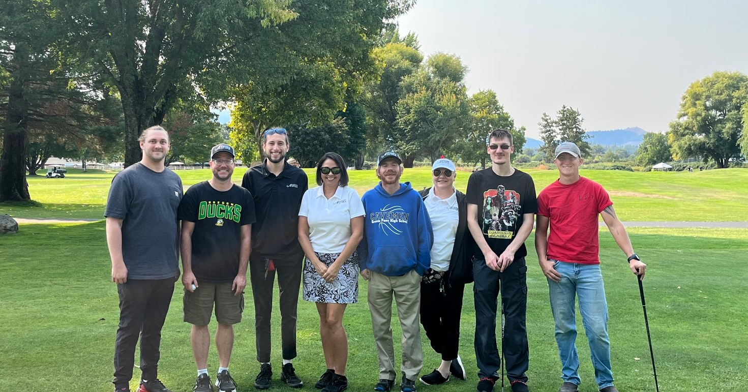 A group of people standing on top of a grass covered field.