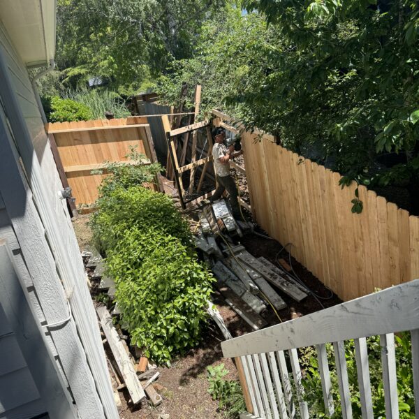 Man repairing fence in backyard