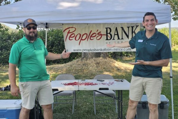 Two men at People's Bank outdoor booth.