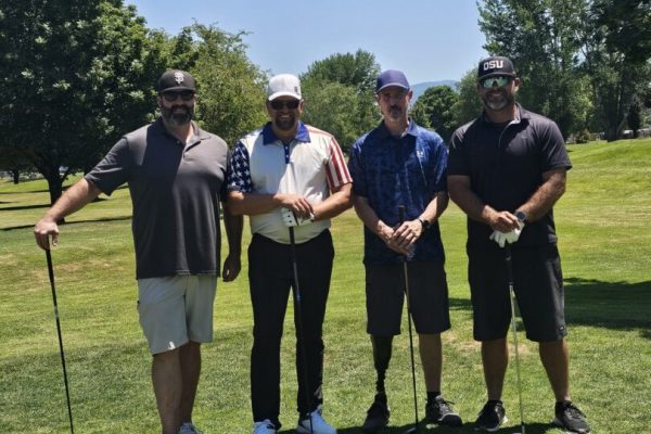Four men standing on a golf course.